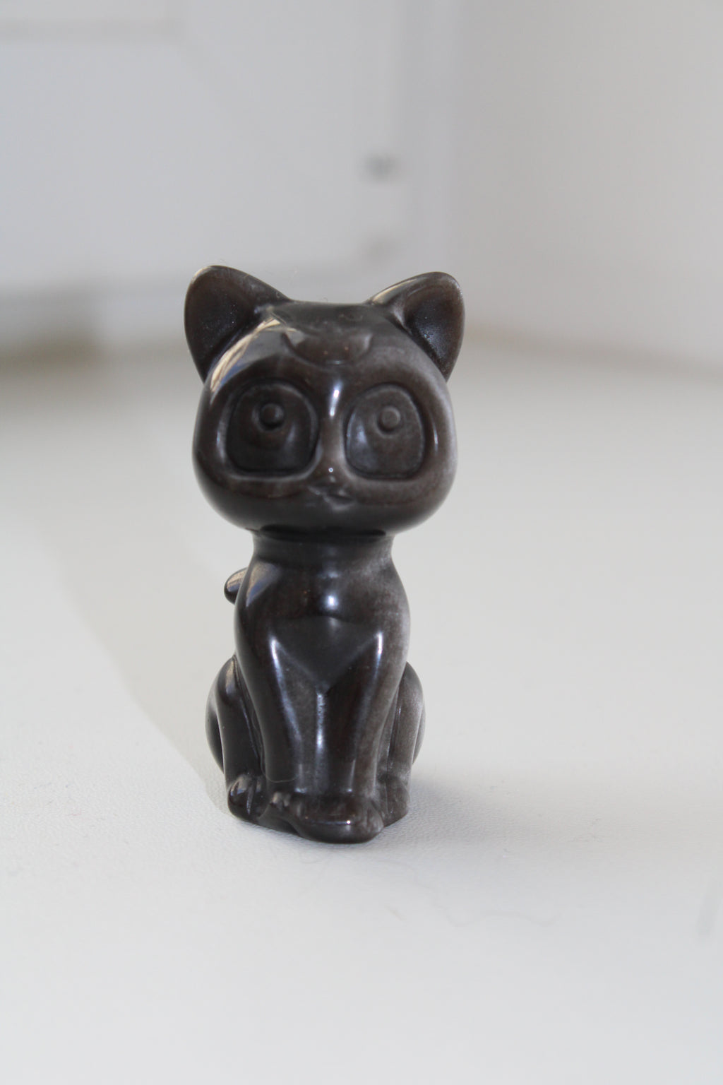 Laissez ce magnifique chat lunaire en obsidienne argentée veiller sur vous, combinant la fidélité éternelle du gardien à l'éclat protecteur de l'amour.