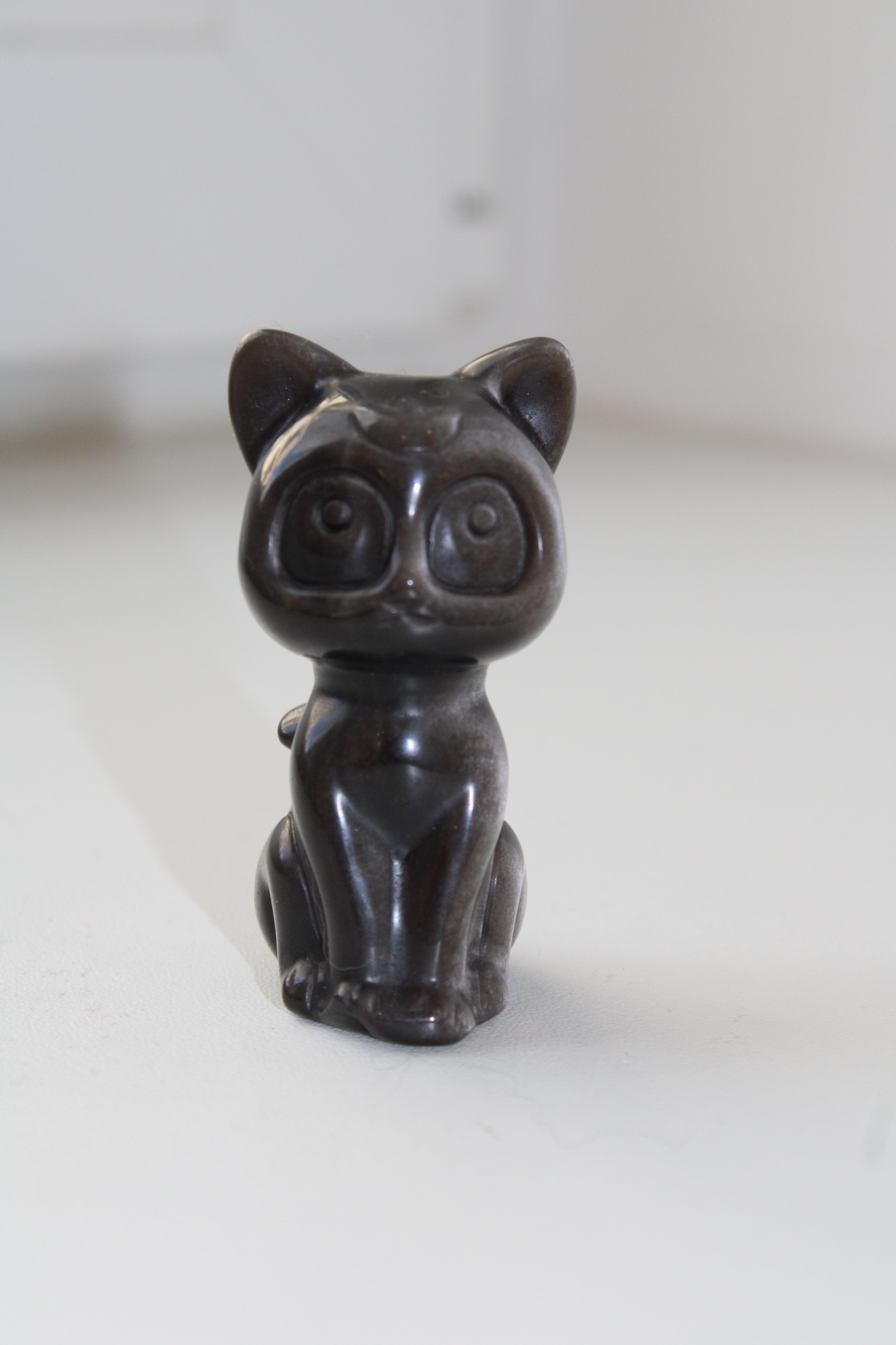 Laissez ce magnifique chat lunaire en obsidienne argentée veiller sur vous, combinant la fidélité éternelle du gardien à l'éclat protecteur de l'amour.