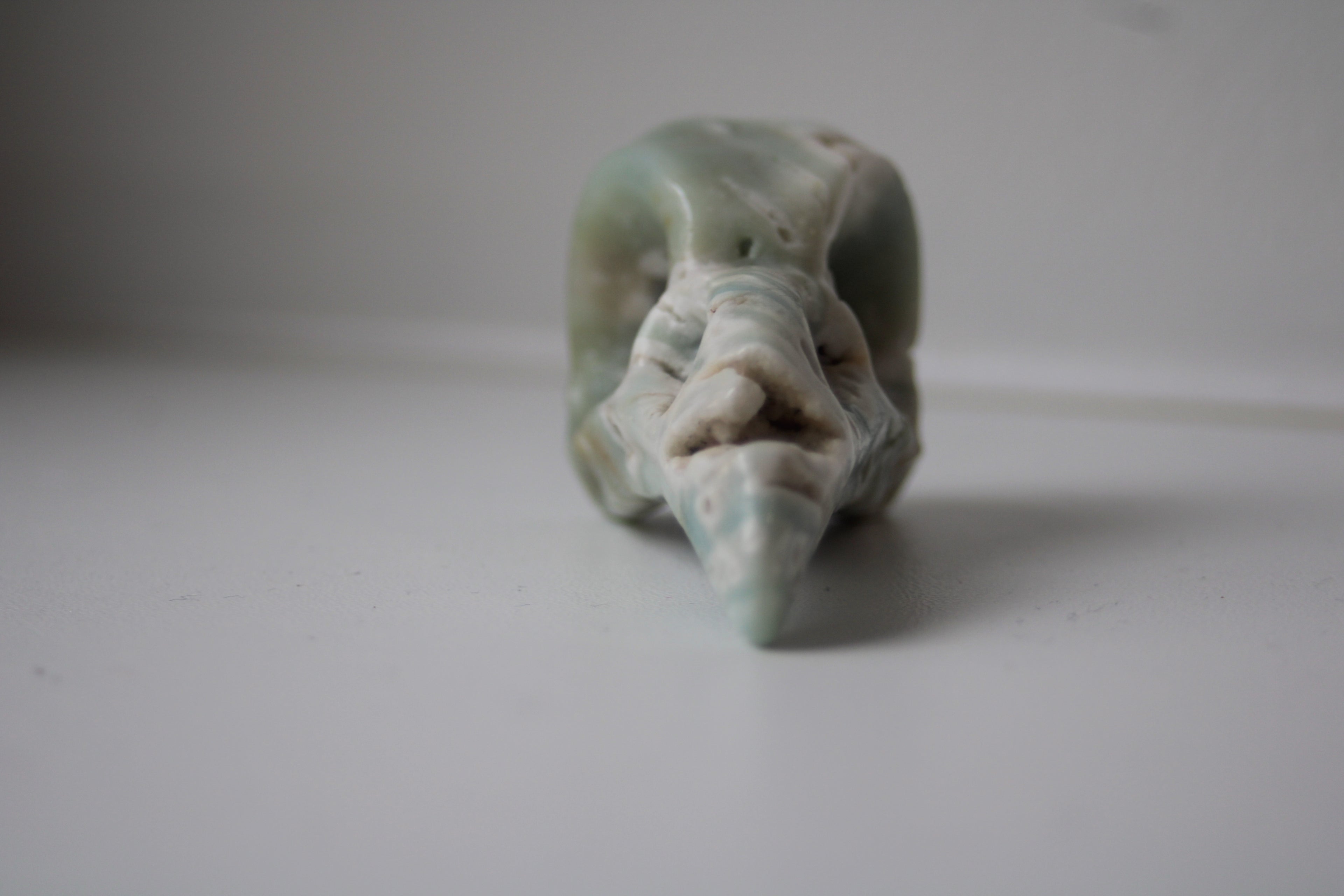 Voyagez aux confins de l'intuition avec ce crâne de corbeau en aragonite bleue, un gardien de sagesse qui diffuse une onde de sérénité absolue dans votre intérieur